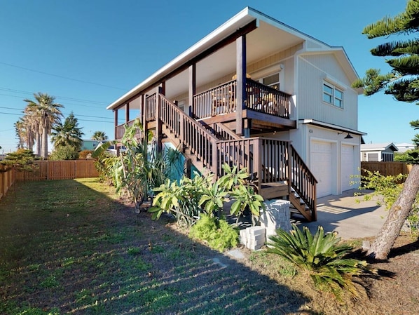 Una casa a due piani con un balcone e un garage.