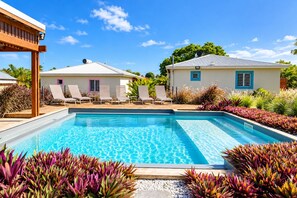 A swimming pool with lounge chairs and a small building with a window. - --- THE FISHERMAN'S SHACK --- (Sainte-Anne)