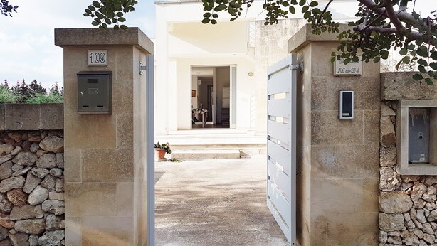 A stone entrance gate with a mailbox and a door leading to a building with a stone wall and a potted plant. - Oikia Holidays Otranto Villa MaGi. <br>Independent villa with large garden. (Otranto)
