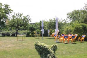 An outdoor seating area with tables and chairs, surrounded by trees. - Casa Rural Bentazar (Legutiano)