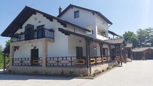 A two-story building with a balcony, a covered porch, and a tiled entrance area. - Popasul Montan (Avrig)