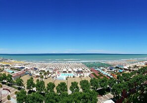A coastal resort with multiple beach umbrellas, a swimming pool, and a variety of beachside accommodations. - Hotel Garden Riccione (Riccione)