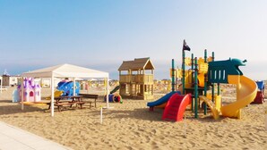 A beach playground with a tent, play structures, and a slide. - Hotel Garden Riccione (Riccione)