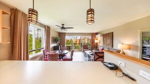 A hotel room with a balcony, a dining area, and a large window with curtains. - 1 Bedroom Garden View Condo  3rd Floor H304- Pono Kai (Kapaʻa)