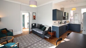 A modern apartment with a living room, dining area, and kitchen. - Troon Golf 2024 (Troon)