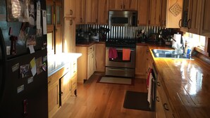 A kitchen with wooden cabinets, a stainless steel oven, and a microwave. - Cozy Quiet Cabin @ Lake Anna (Mineral)