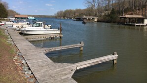 A dock with boats, a wooden pier, and a building with a roof on the water. - Cozy Quiet Cabin @ Lake Anna (Mineral)