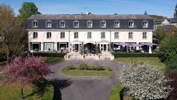 A large, two-story building with a symmetrical facade, multiple windows, and a central entrance with a canopy. - Le Pré Saint Germain (Louviers)