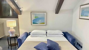 A hotel room with a bed, two pillows, a lamp, and a painting on the wall. - Ca Moro - Deluxe Loft with Private Terrace (Venezia)