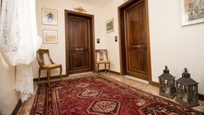 A hallway with two wooden doors, a patterned carpet, and two chairs. - Ca Moro - Deluxe Loft with Private Terrace (Venezia)
