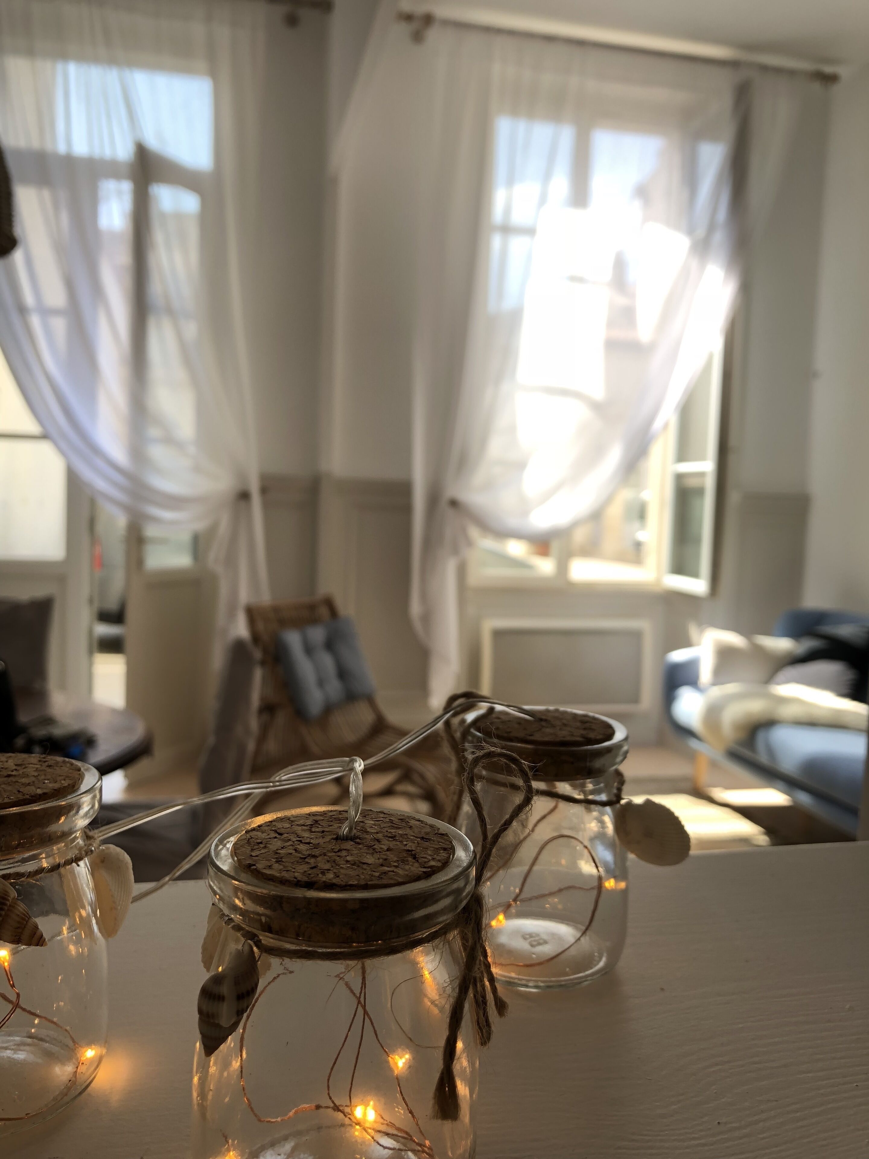 Una habitación acogedora con una mesa que muestra botes con tapones de corcho y luces de hadas.