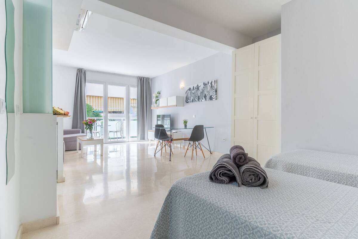 Une chambre d’hôtel moderne dotée d’un grand lit, d’un bureau et d’un balcon.