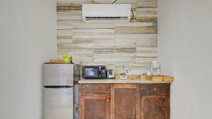 A kitchen with a refrigerator, microwave, and wooden cabinets. - The Ideal Loft (Nassau)