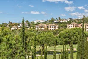 A resort with multiple buildings, lush greenery, and a golf course.