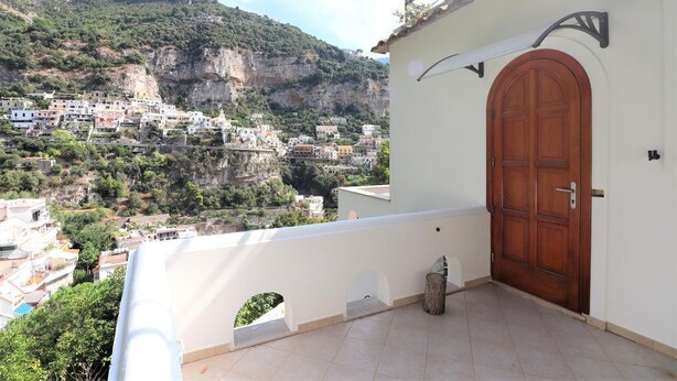 Un balcón con vistas a un pueblo costero y acantilados.