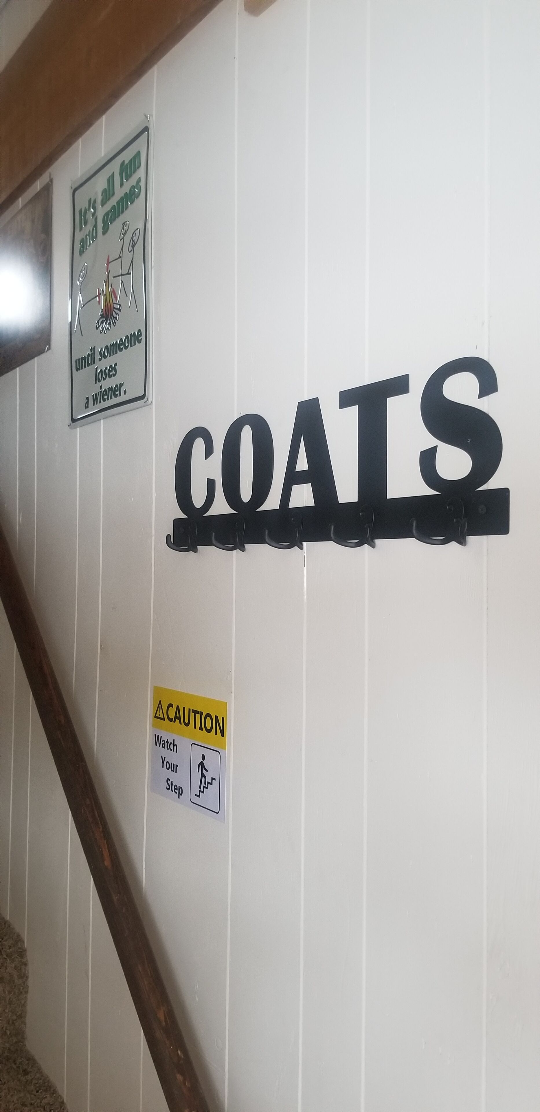 A wall with the word "COATS" and two caution signs.