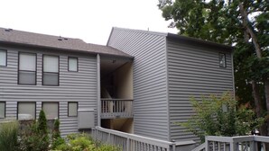 A two-story building with a balcony on the second floor, a wooden deck, and a landscaped garden area with various plants. - Amazing Views and Two Kayaks Ready to Use! (Moneta)
