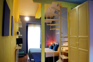 A bedroom with a bed, a desk, a chair, a wardrobe, and a spiral staircase. - Aloque Posada (Valdepenas)