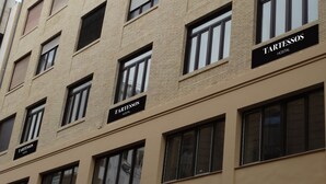 Ein mehrgeschossiges Gebäude mit mehreren Fenstern und Schildern mit der Aufschrift "TARTESSOS HOSTAL".