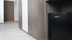 Eine moderne Küche mit einem schwarzen Kühlschrank, Holzschränken und einem Fliesenboden.