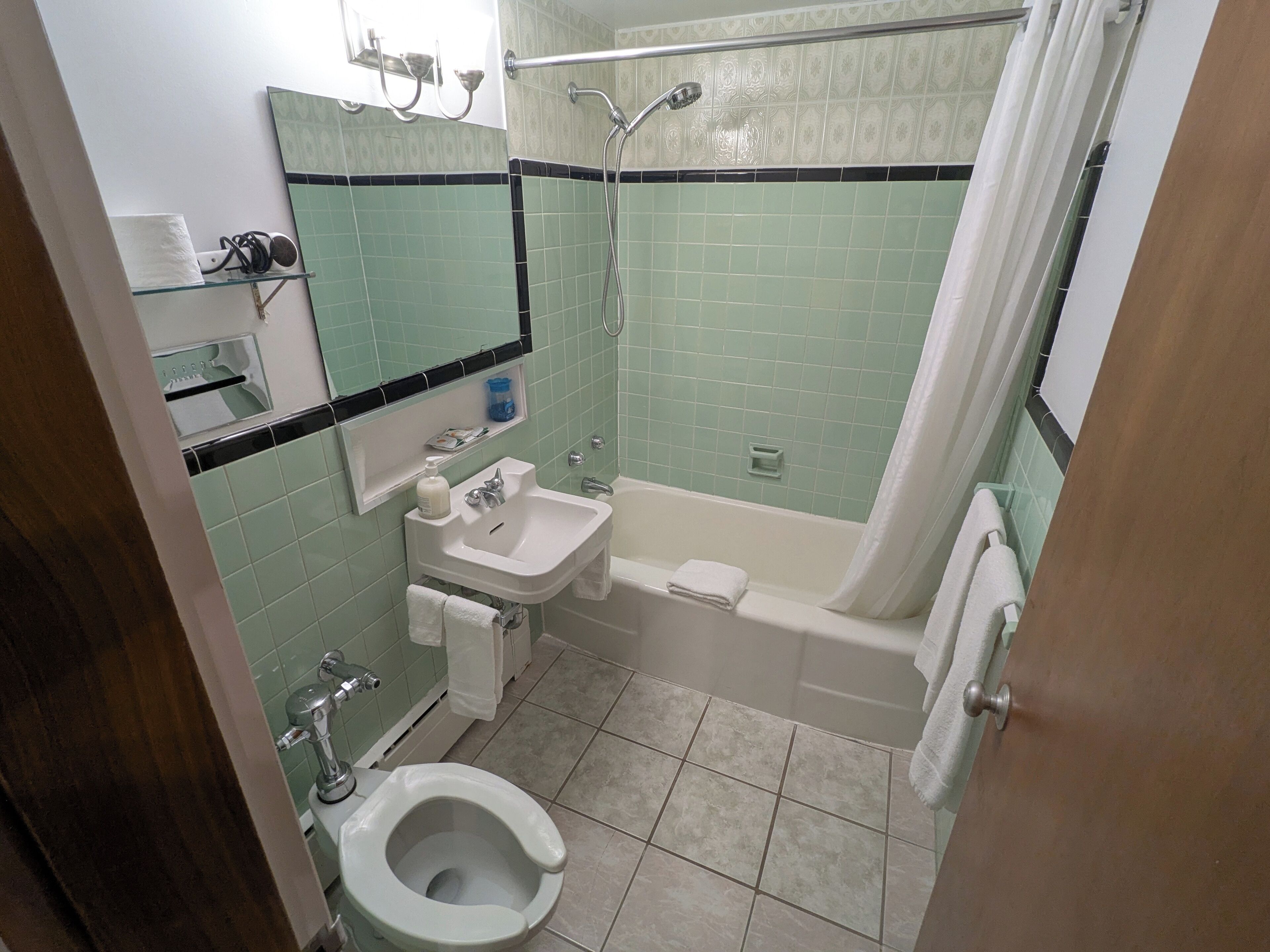 A bathroom with a toilet, sink, bathtub, and shower.