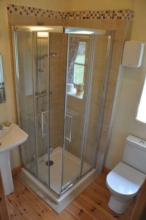 Een douche, handdoeken, zeep, toiletpapier