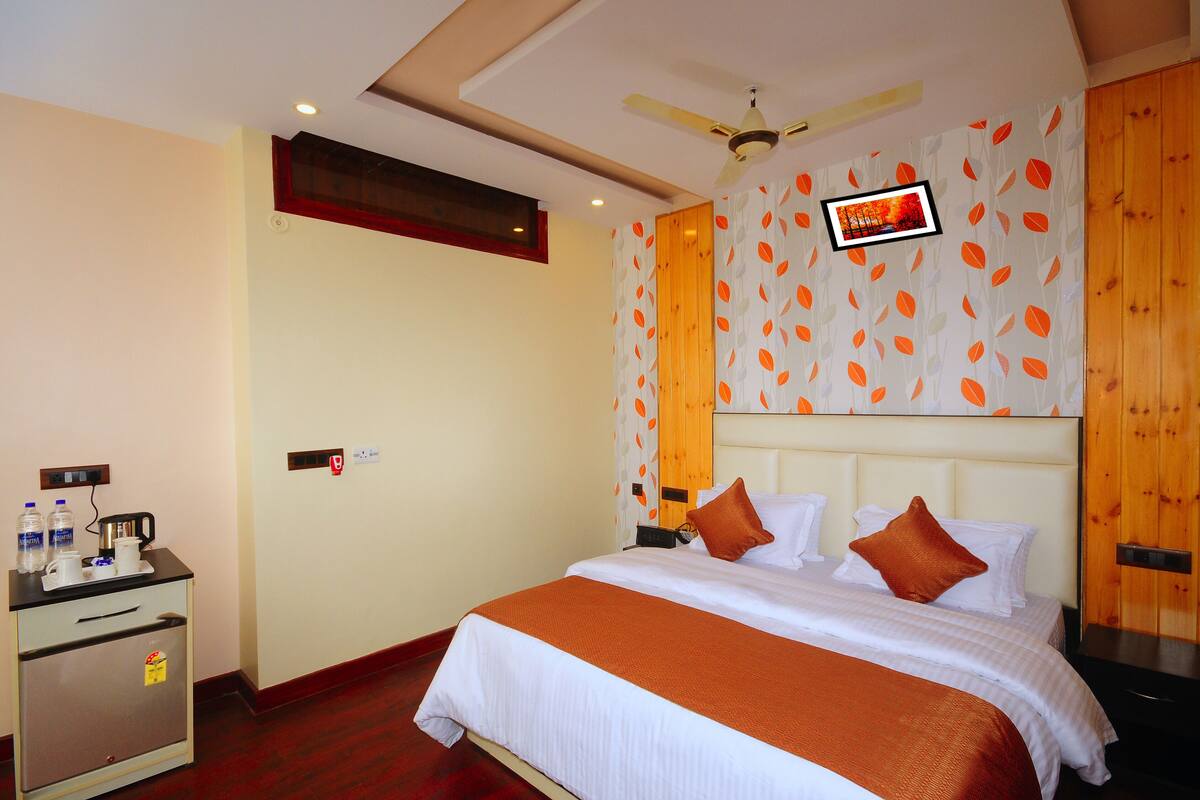 Een hotelkamer met een bed, een bureau met koffiezetapparaat en een kledingkast.