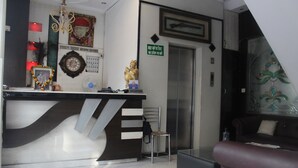Un mostrador de recepción de diseño moderno, un cartel de recepción, una estatua y un reloj de pared.