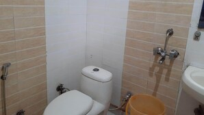 Un baño pequeño con inodoro, lavamanos y ducha.