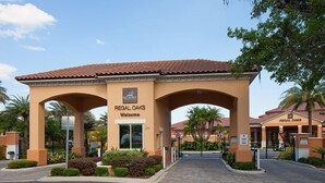 A hotel entrance with a sign reading "Regal Oaks Welcome."