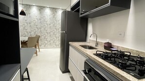 Una cocina moderna con estufa a gas, refrigerador y pileta.