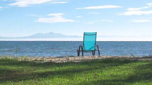 A beach chair by the water with a clear view of the sea and distant mountains. - Villa Sevasti (Katerini)