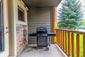 A barbecue grill on a porch with a 'No Smoking' sign, a stone wall, and a wooden railing. - 1 Bedroom Plus Studio Lock-Off Unit. AC (Fernie)