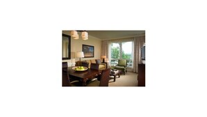 A hotel room with a dining area, a sofa, a television, and a window with a view of greenery. - Westin Princeville 2 Bedrooms Premium Unit  (Princeville)