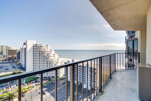 Un balcón con vista al océano y al paisaje urbano.