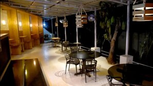 Un restaurant doté de nombreuses tables et chaises, de lambris en bois aux murs et de luminaires suspendus.