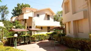 Un immeuble de deux étages, doté d’un toit plat et d’un balcon à l’étage supérieur.