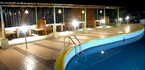 A poolside area with seating and a pool. - Hotel Mount Castle (Wai)