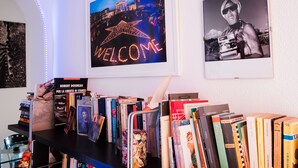 Een boekenplank met diverse boeken en een bord met een welkomstboodschap.
