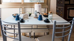 Een keuken met een wit aanrecht, een koffiezetapparaat, een waterkoker en een schaal met koekjes.