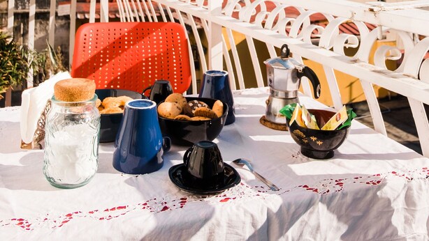 Een tafel op een balkon met uitzicht op de stad, inclusief gebouwen en een koepel.