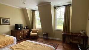 A hotel room with two beds, a ceiling fan, a desk, a chair, a TV, and large windows with curtains. - Blueberry Plantation Golf Resort (Alma)