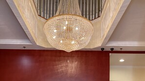 A reception desk with a chandelier, a framed painting, and a floral arrangement. - Blueberry Plantation Golf Resort (Alma)