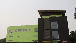 Un bâtiment moderne doté d’une façade verdoyante et d’une partie noire surmontée d’un toit en pente.