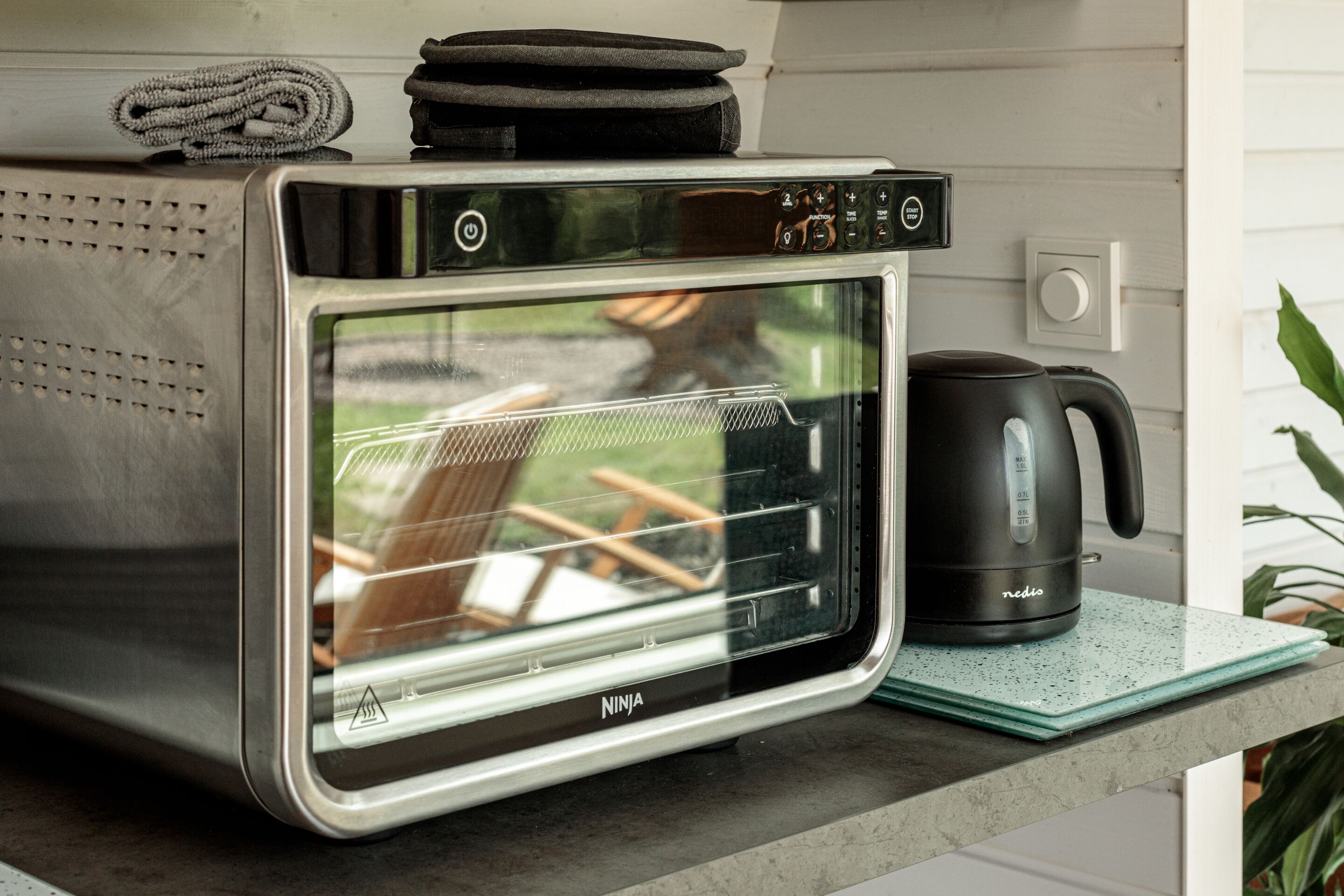 Una cocina con horno de acero inoxidable, hervidor y encimera.