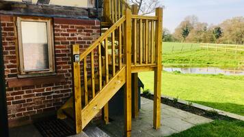 A wooden staircase leading to a brick building with a window.