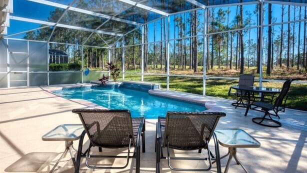 A covered outdoor pool area with a clear view of the surrounding forest. - SVV 076 - Villa Reserve 5 Bed Pool Home (Davenport)