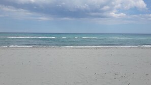 A beach with a wide sandy shore and gentle waves.