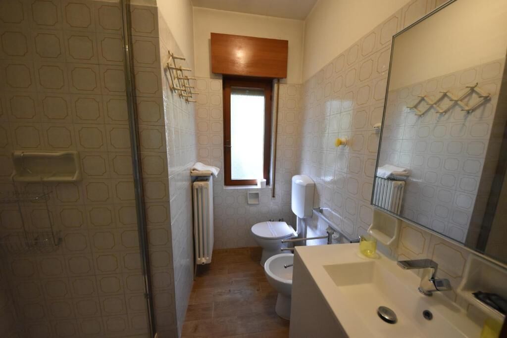 A bathroom with a shower, toilet, and sink.
