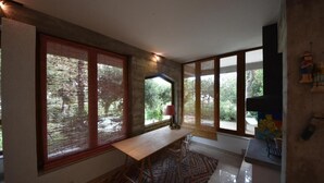 Une cuisine moderne avec de grandes fenêtres, une table en bois et un tapis à motifs.